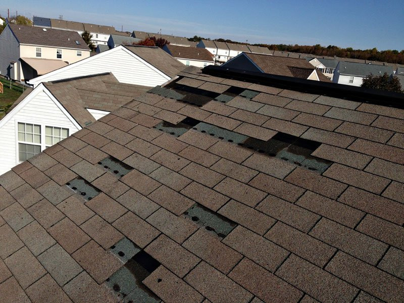storm damaged roof with missing shingles